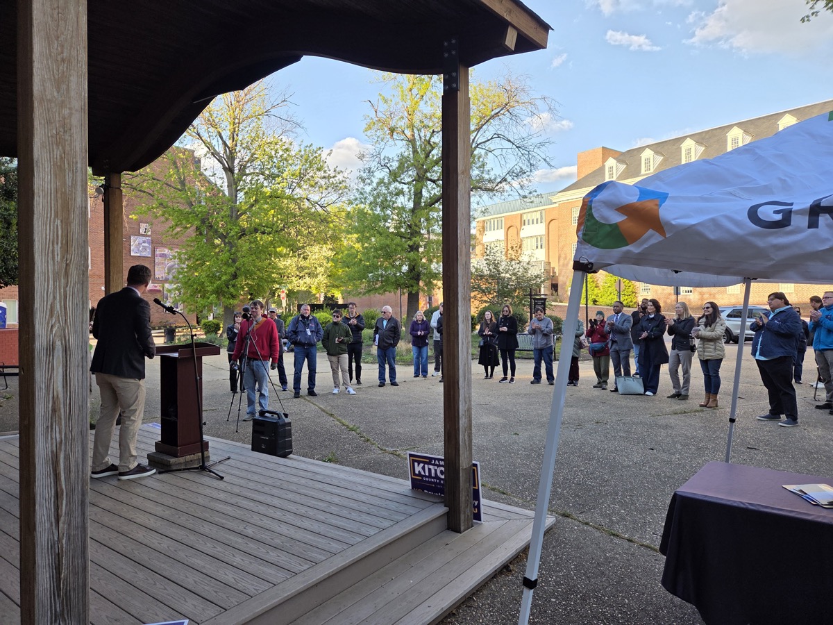 James speaking at outdoor rally with crowd