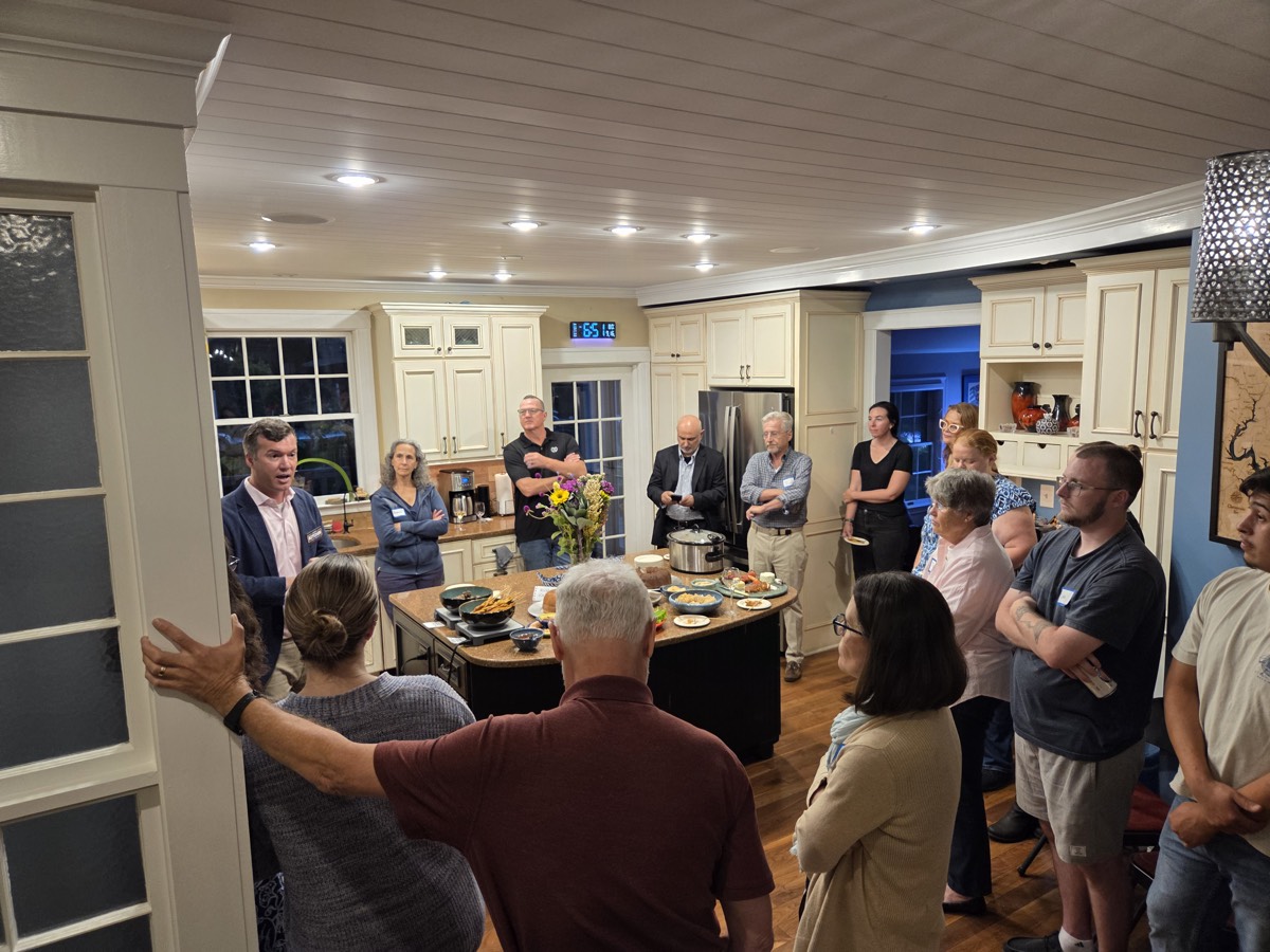James speaking to a packed house party
