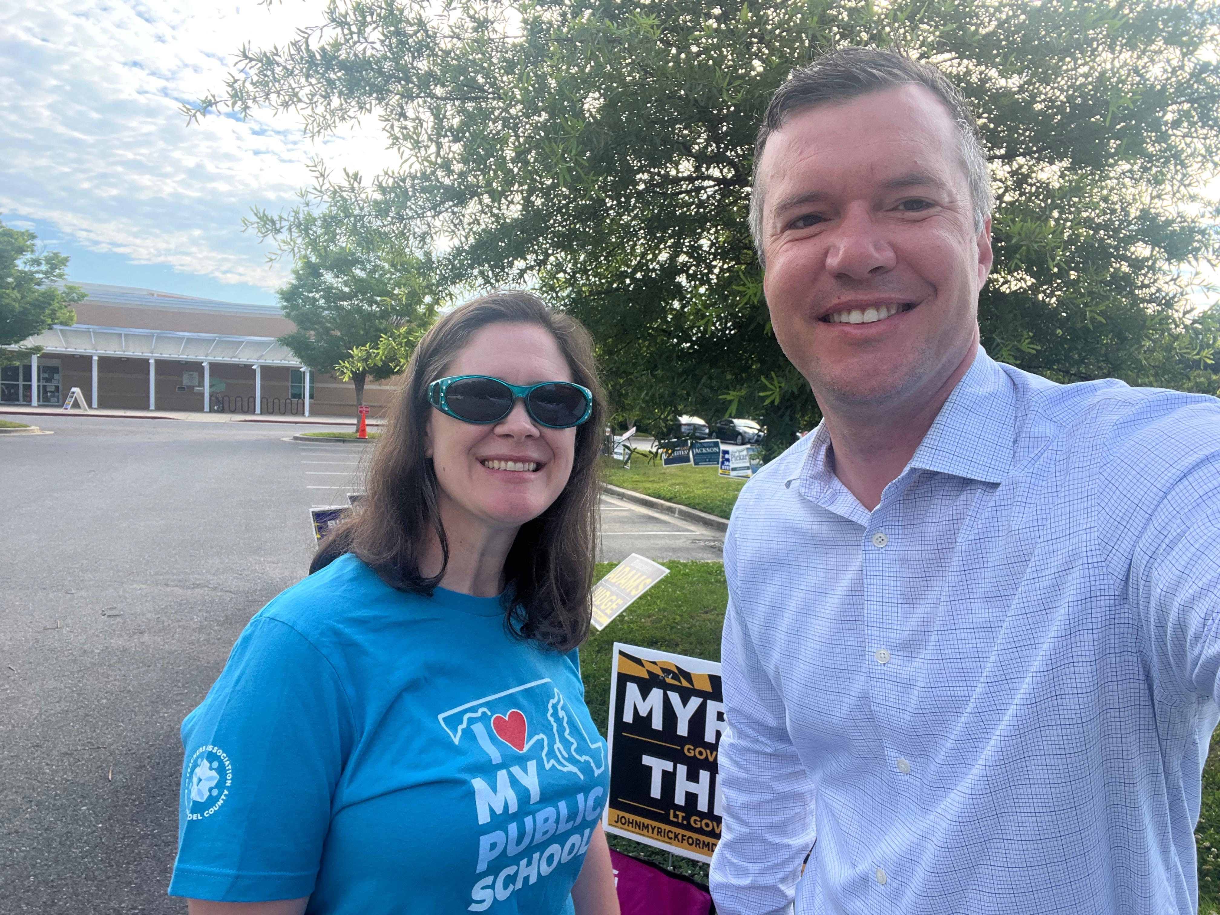 An educator in 'I Love My Public Schools' shirt with James Kitchin at a polling place