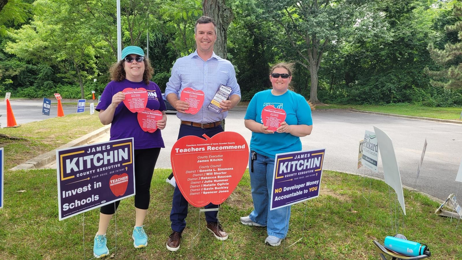 Three teachers and James Kitchin holding Teachers Recommend Apple Ballots at the polls